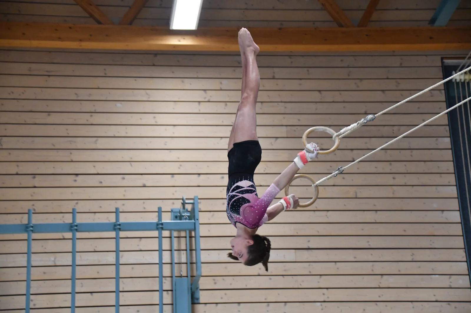 Geräteturnerinnen beim Training an Reck, Schaukelringen und Sprung